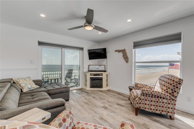 living room with a healthy amount of sunlight, ceiling fan, and light hardwood / wood-style floors