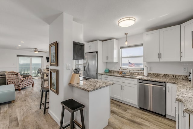 kitchen featuring a healthy amount of sunlight, white cabinetry, appliances with stainless steel finishes, and a sink