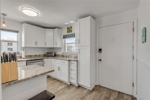 kitchen featuring light wood-type flooring, white cabinets, and stainless steel dishwasher