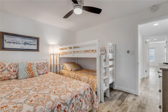 bedroom with a ceiling fan, baseboards, and wood finished floors