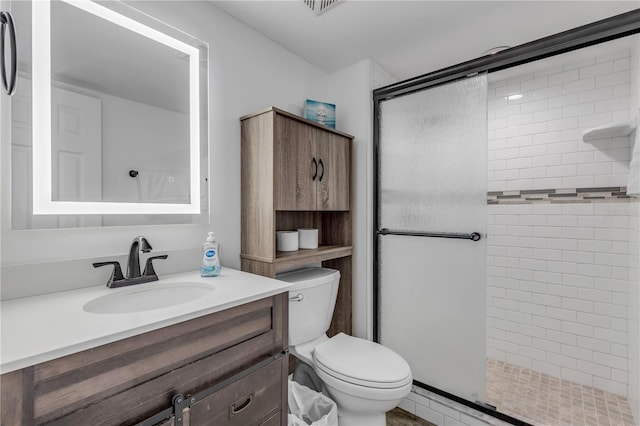 full bath featuring toilet, a stall shower, and vanity