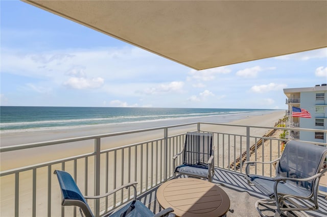 balcony featuring a water view and a view of the beach