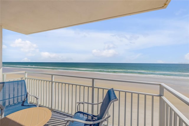 balcony featuring a water view and a view of the beach