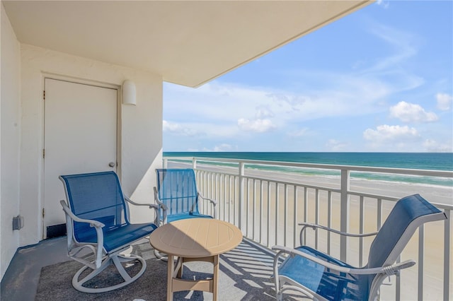 balcony featuring a water view and a beach view