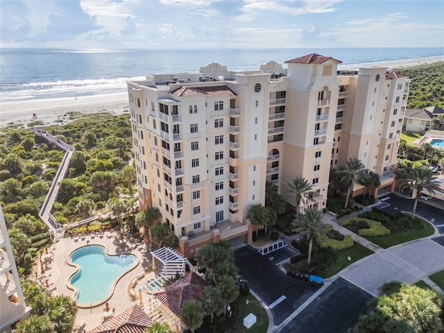 drone / aerial view with a water view and a beach view