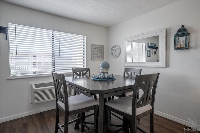 dining space featuring dark wood-type flooring and a textured ceiling