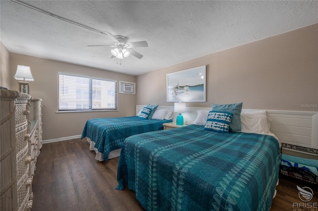 bedroom featuring ceiling fan, a wall unit AC, dark hardwood / wood-style floors, and a textured ceiling