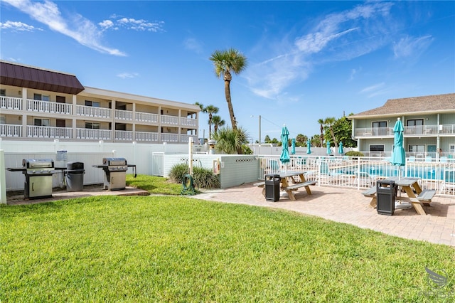 view of home's community with a lawn, a patio area, and a swimming pool