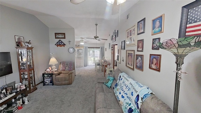 carpeted living room with ceiling fan and vaulted ceiling