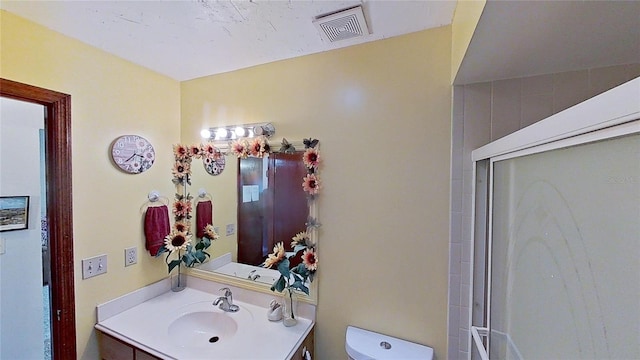 bathroom featuring vanity, toilet, and walk in shower