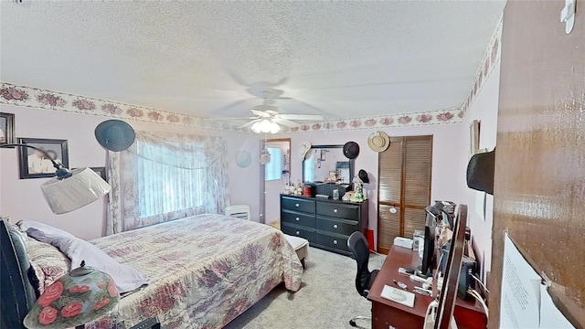 bedroom with a textured ceiling, ceiling fan, and carpet