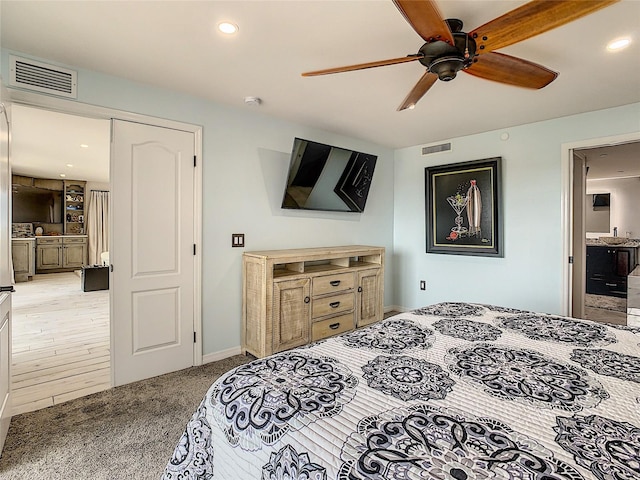 bedroom featuring a closet, ceiling fan, ensuite bath, and light hardwood / wood-style flooring