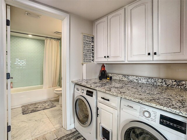 laundry area featuring washer / clothes dryer and cabinets