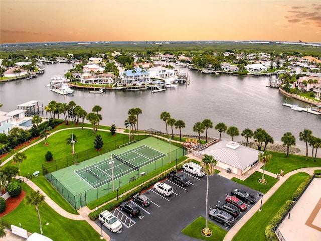 aerial view at dusk featuring a water view