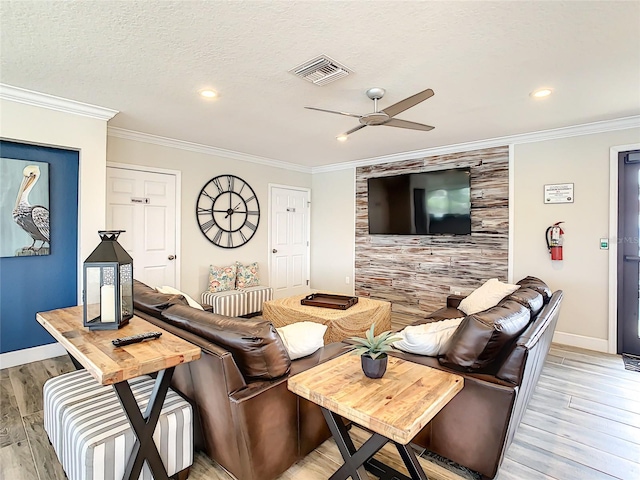 living room with crown molding, ceiling fan, and light hardwood / wood-style floors