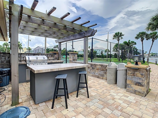 view of patio / terrace featuring exterior bar, a pergola, and area for grilling