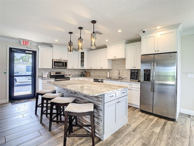 kitchen featuring appliances with stainless steel finishes, white cabinetry, and light hardwood / wood-style flooring