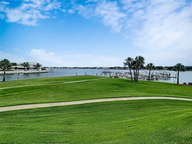 view of home's community with a water view and a yard