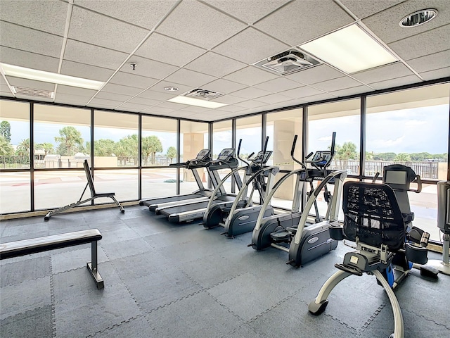 workout area with plenty of natural light and a drop ceiling