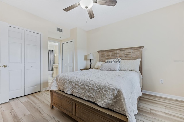 bedroom featuring ceiling fan, connected bathroom, light hardwood / wood-style floors, and multiple closets