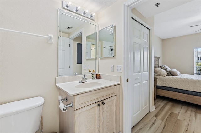 bathroom featuring toilet, hardwood / wood-style flooring, and vanity