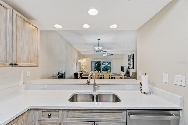 kitchen with decorative light fixtures, stainless steel dishwasher, sink, light brown cabinets, and ceiling fan