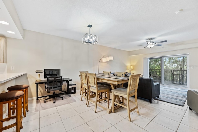 dining room with light tile patterned floors, ceiling fan with notable chandelier, and a textured ceiling