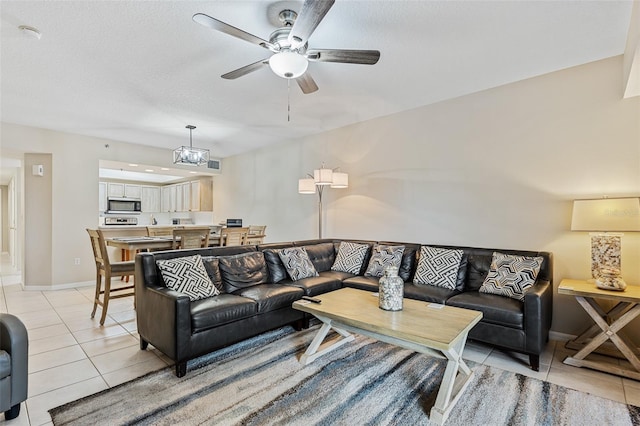 living room featuring a textured ceiling, ceiling fan, and light tile patterned flooring