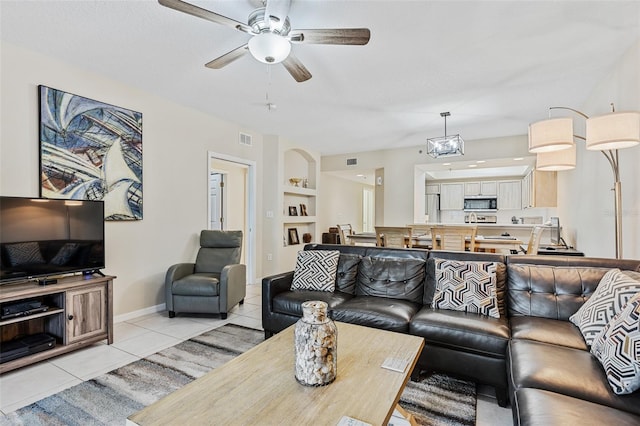 living room with a textured ceiling, ceiling fan, and light tile patterned floors