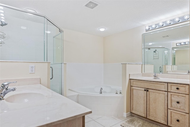 bathroom with tile patterned floors, independent shower and bath, a textured ceiling, and vanity