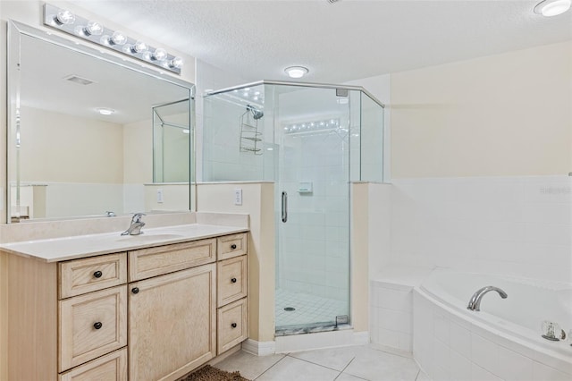 bathroom with tile patterned floors, separate shower and tub, a textured ceiling, and vanity