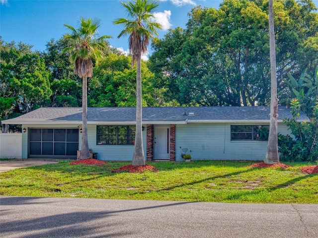 single story home featuring a garage and a front lawn