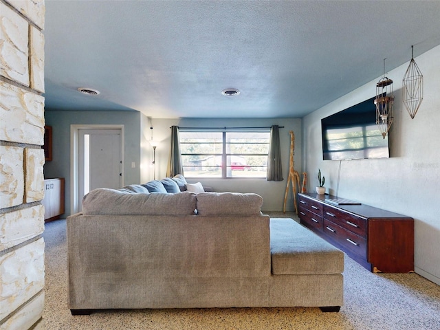 living room featuring a stone fireplace and a textured ceiling