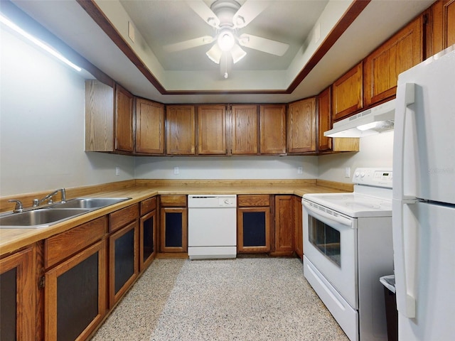 kitchen featuring a raised ceiling, white appliances, sink, and ceiling fan