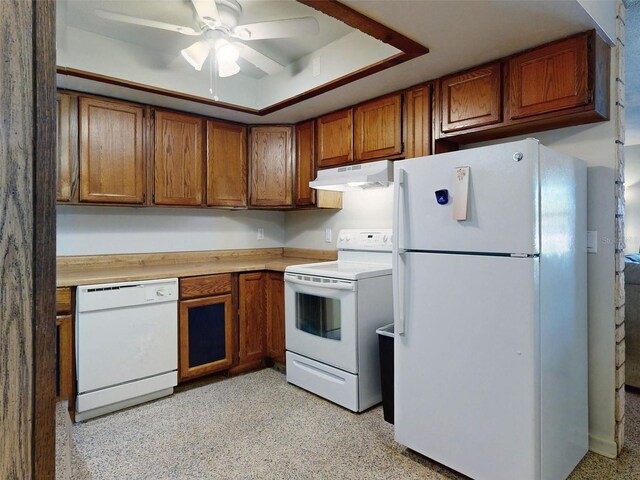 kitchen featuring ceiling fan, white appliances, and a tray ceiling