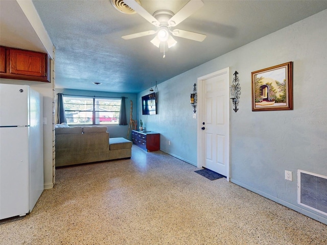 kitchen featuring white refrigerator, a textured ceiling, and ceiling fan