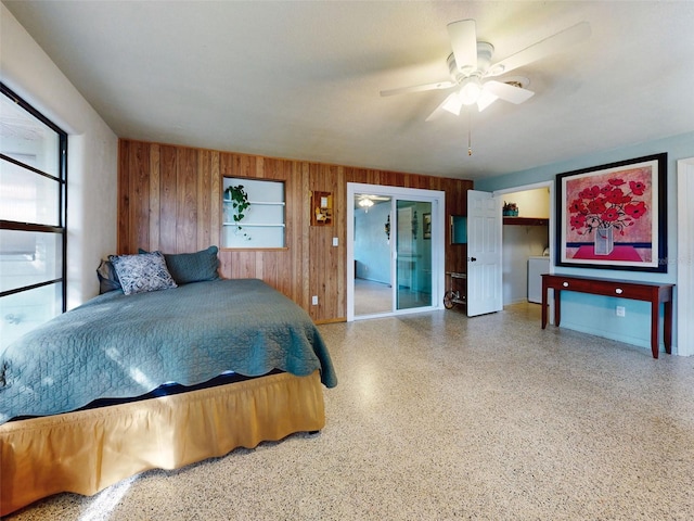 bedroom featuring access to exterior, ceiling fan, and wood walls