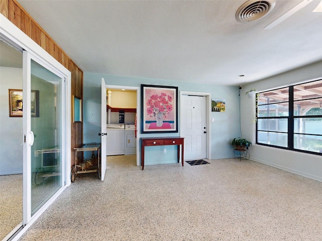 interior space featuring washing machine and clothes dryer and a textured ceiling