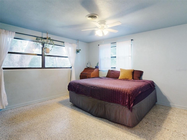 bedroom with a textured ceiling and ceiling fan