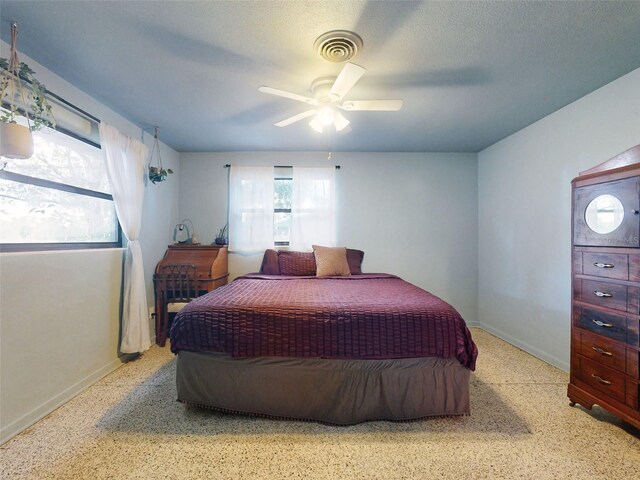 bedroom with a textured ceiling and ceiling fan