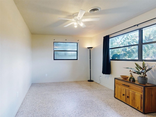 spare room featuring a healthy amount of sunlight and ceiling fan