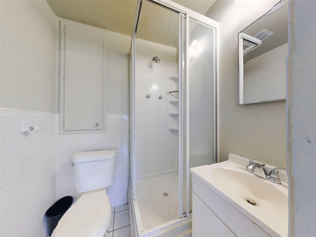 bathroom featuring vanity, toilet, an enclosed shower, and tile walls