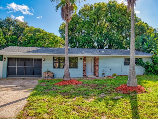 ranch-style house featuring a garage and a front lawn