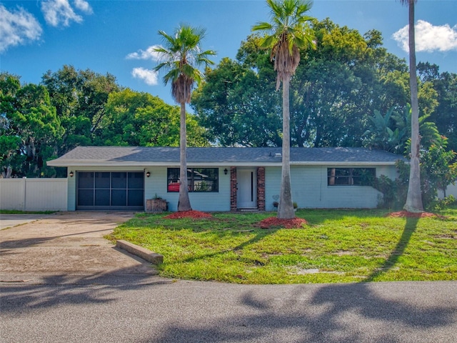 ranch-style house featuring a garage and a front yard