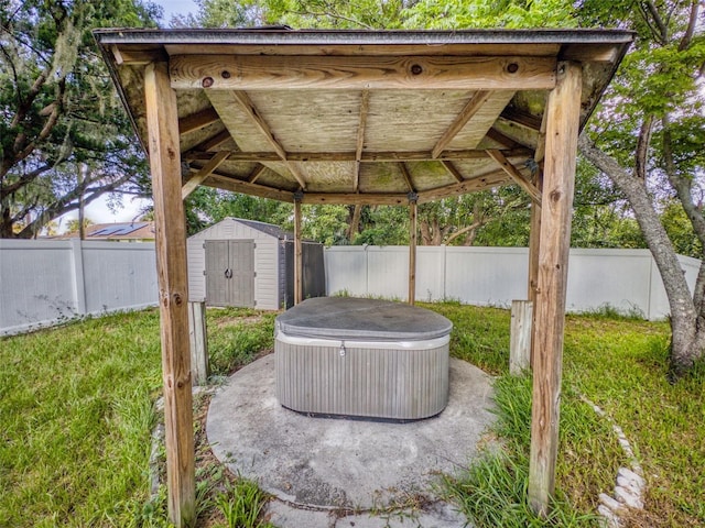 view of patio / terrace featuring a gazebo, a hot tub, and a shed