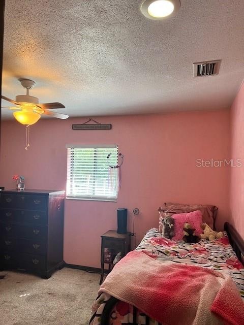 carpeted bedroom featuring a textured ceiling and ceiling fan