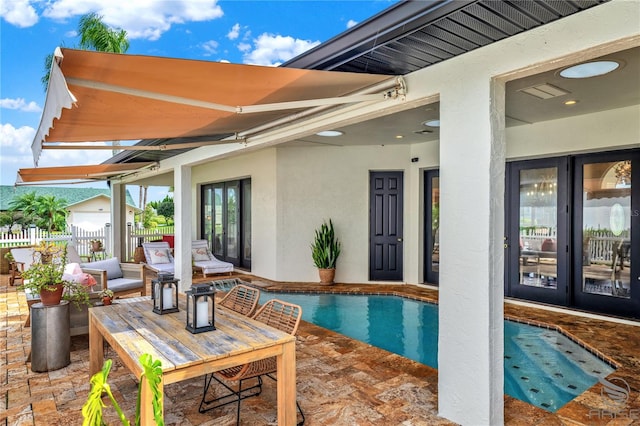 view of swimming pool featuring a patio and french doors