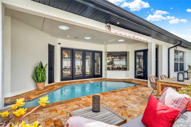 view of swimming pool with a patio area and french doors