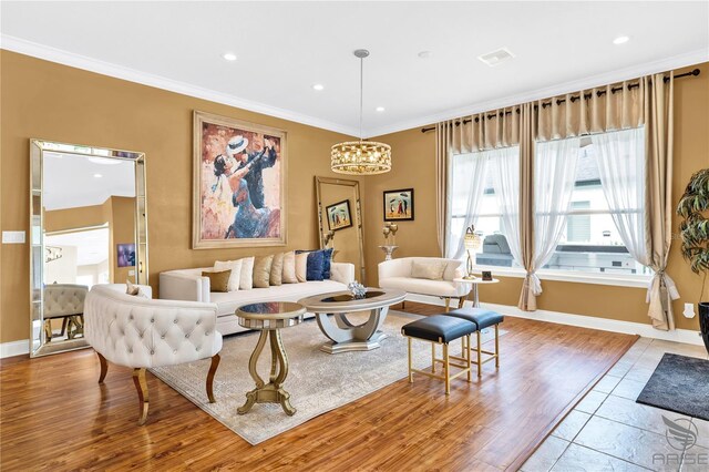 living room featuring light hardwood / wood-style flooring, an inviting chandelier, and crown molding