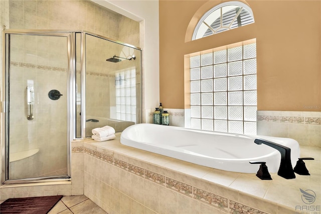 bathroom with tile patterned flooring and separate shower and tub